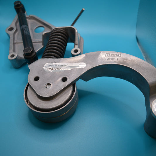 A belt tensioner assembly with a metal tensioner and a spring, likely made of steel, placed on a blue background.