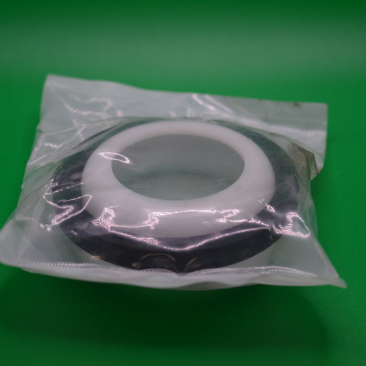 Crankshaft seal packaged in plastic, displayed on a green background
