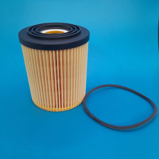 A Gen 1 Min cooper oil filter with a black top and a pleated filter media, displayed against a blue background.