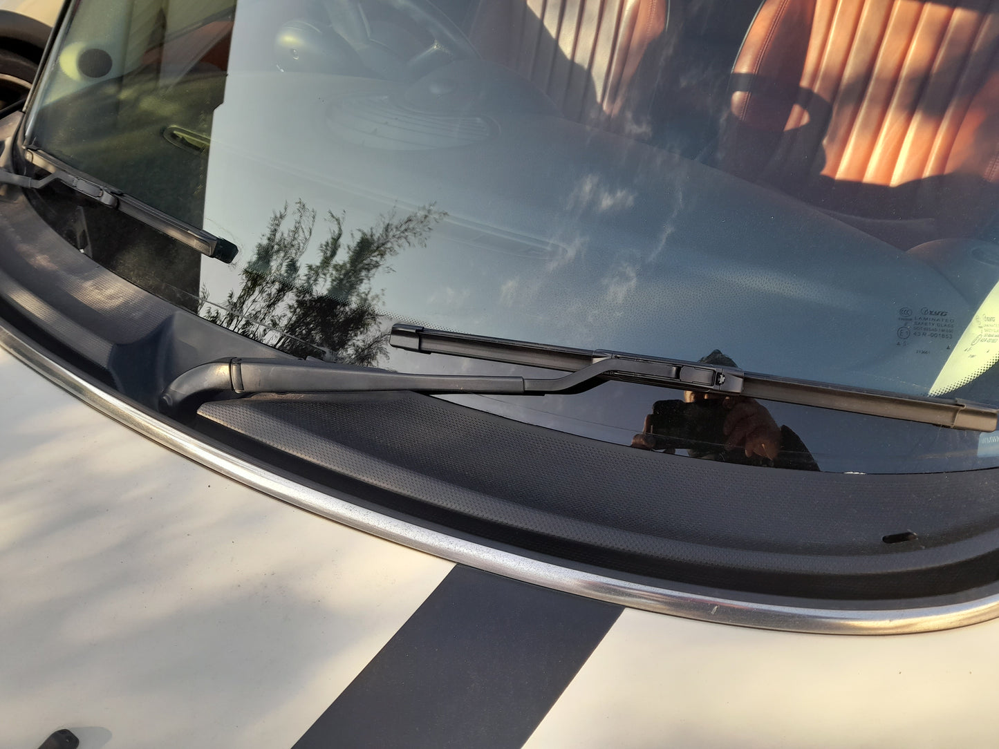 A close-up of the front of a Gen 2 Mini Cooper vehicle showing the flex blade wiper set in action.