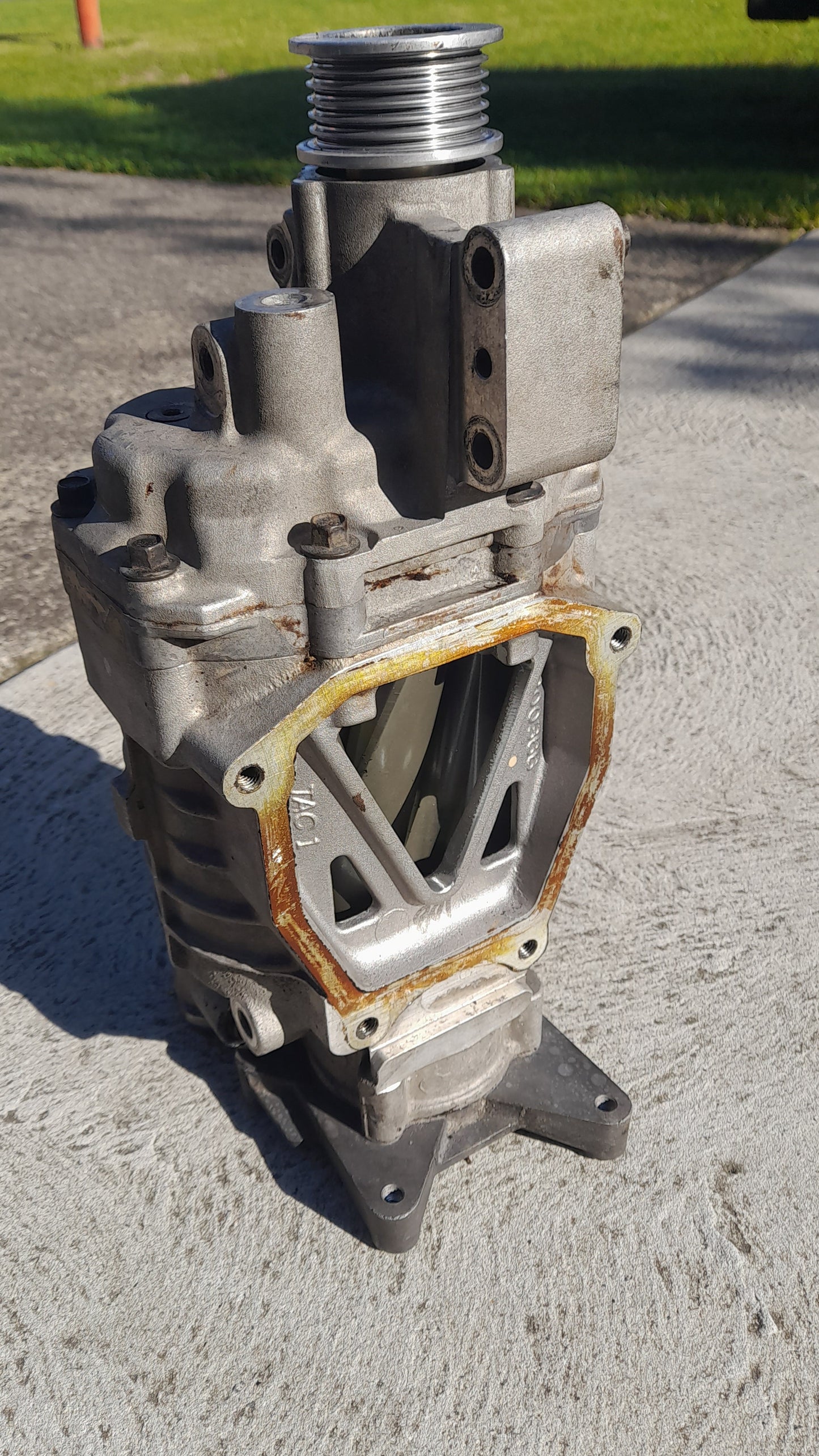 A used second hand super charger for a Mini cooper S, with visible signs of wear and aftermarket pulley.