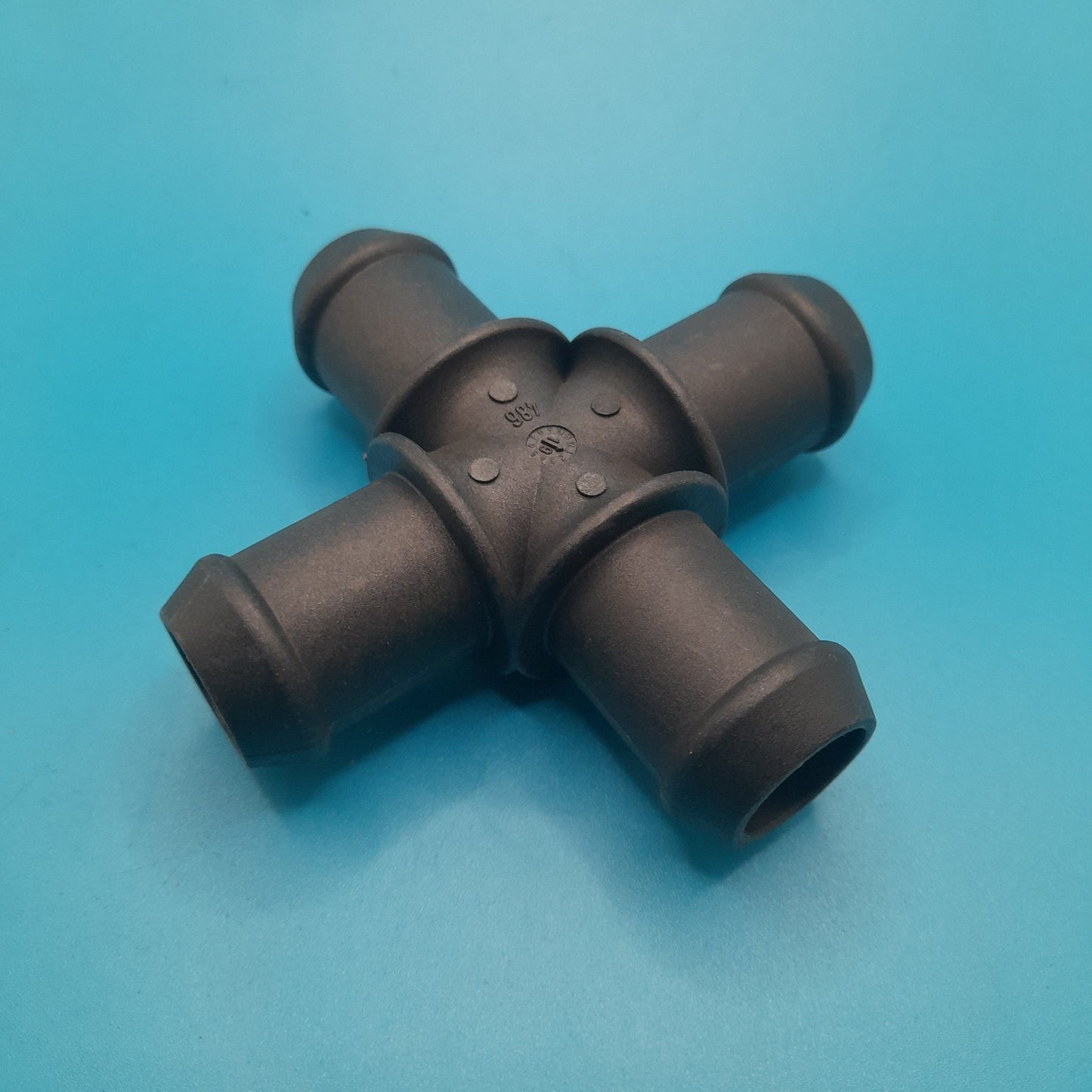 A black heater hose cross connection fitting for a Mini Cooper vehicle.