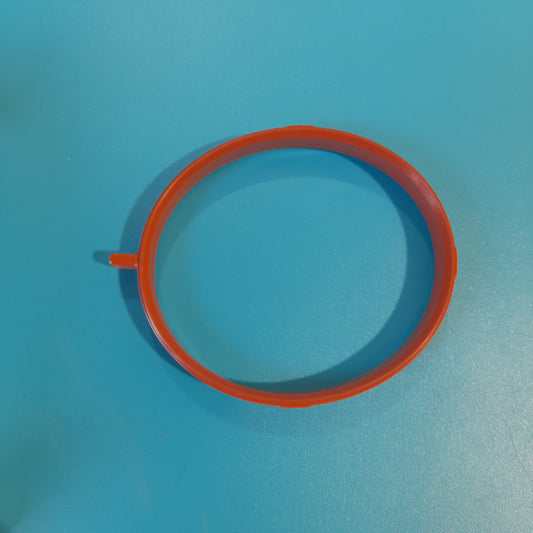 An orange gasket for a Mini Cooper S throttle body placed on a blue surface. r52,r53