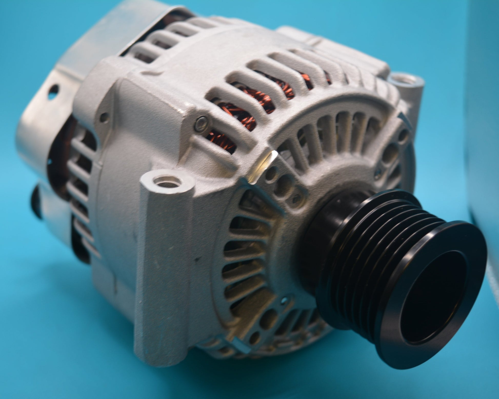 A white alternator with copper wiring and connectors, designed for use in a vehicle's electrical system.