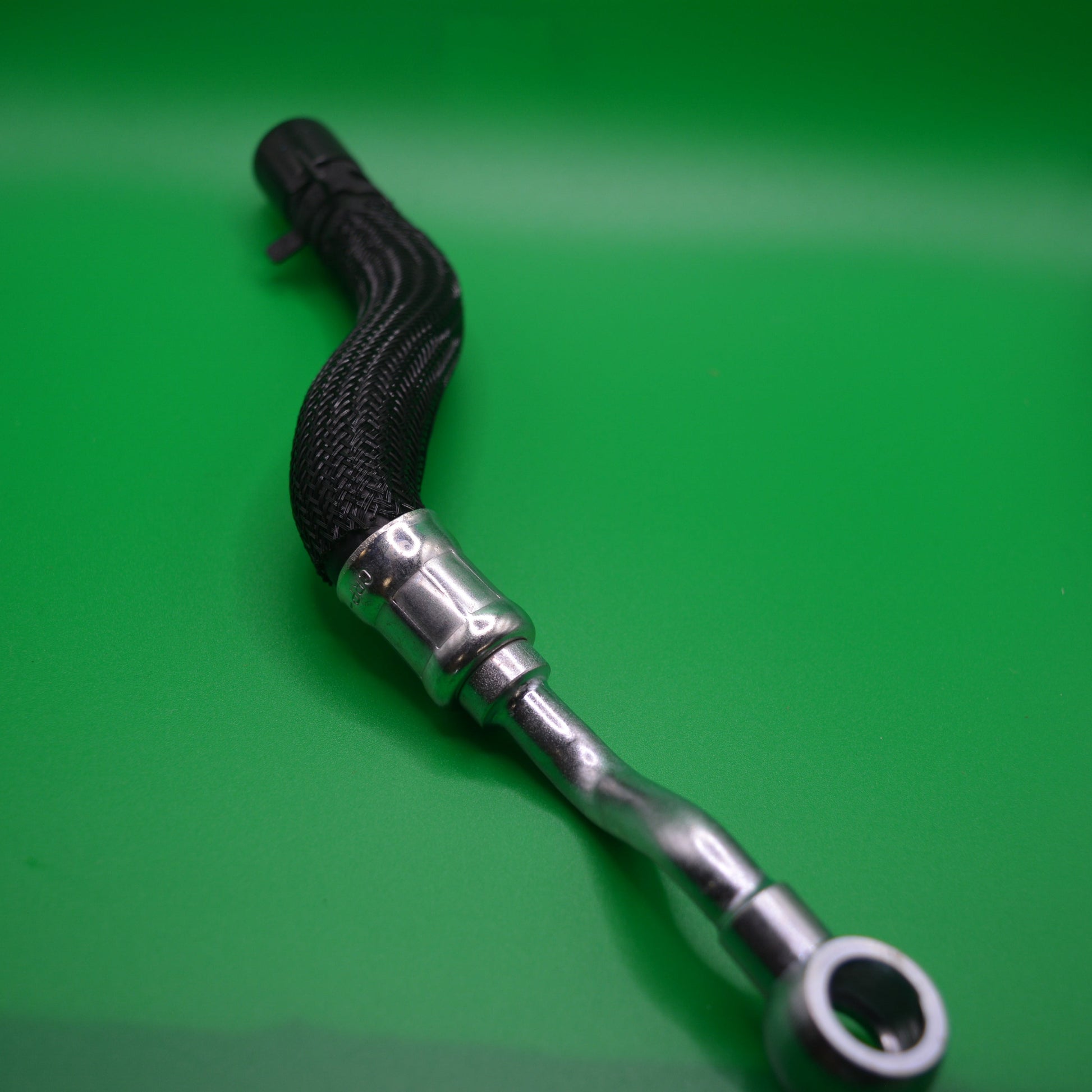 A lower turbo coolant pipe for R55 & R56 MINI, featuring a metallic part and a black hose.