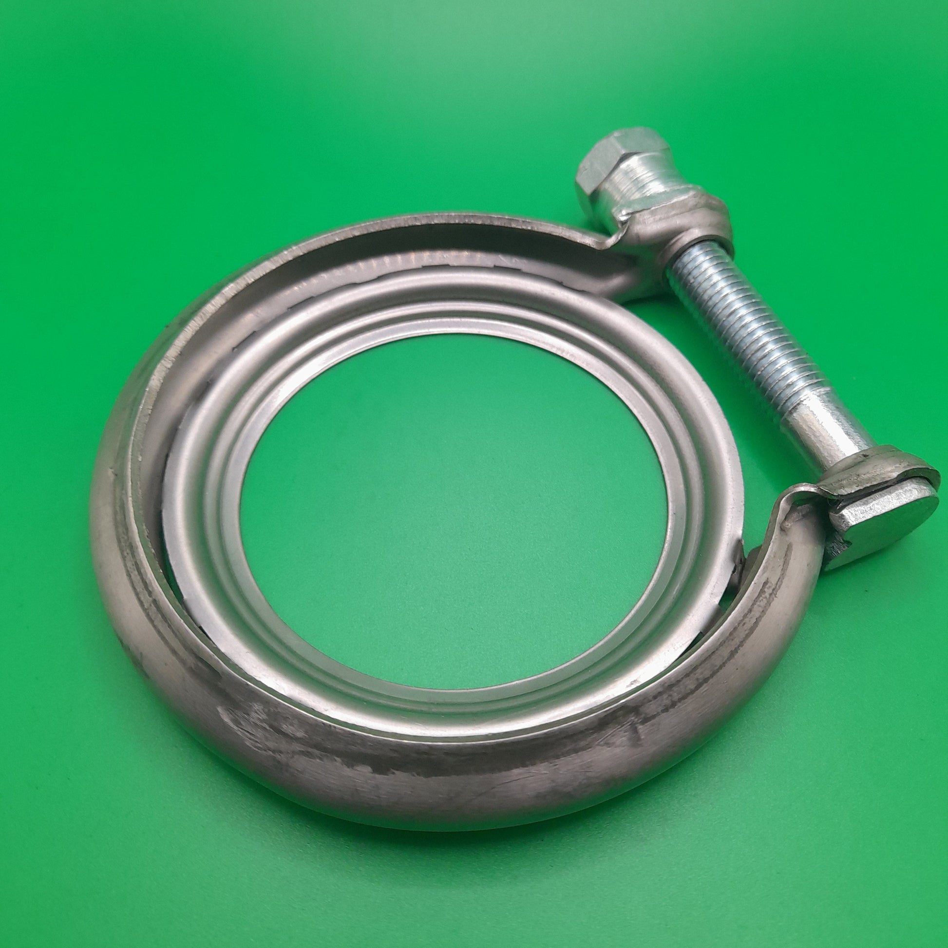 A silver-colored metal exhaust clamp for R55 and R56 Mini models, displayed on a green background.