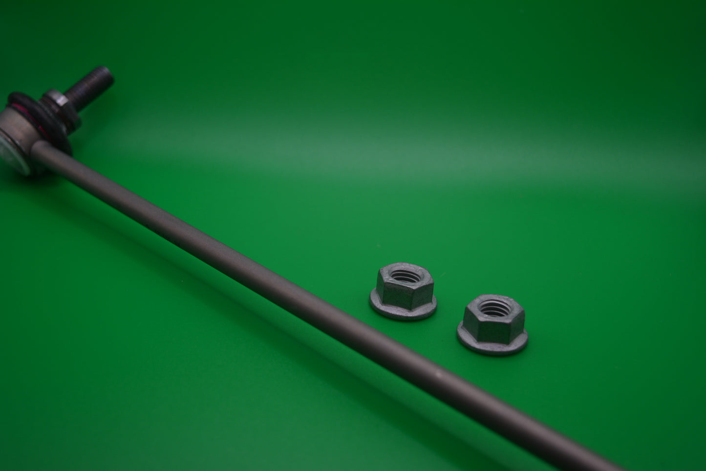 A front sway bar link with two bolts on a green background, typically used for connecting the sway bar to the suspension in mini cooper R56 models