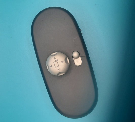 A black Mini Cooper side view mirror switch with visible signs of wear.