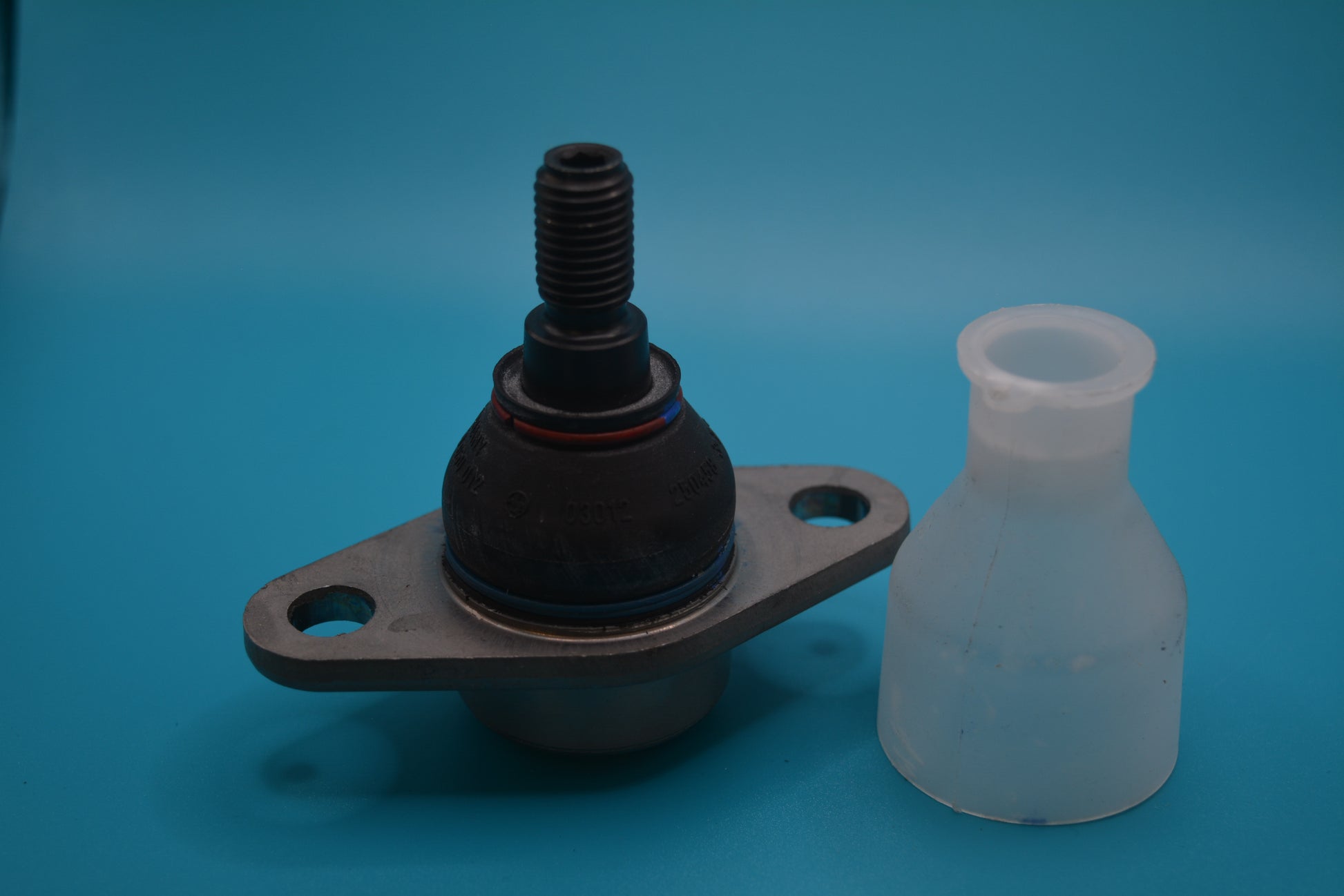 An outer lower ball joint for a Mini Cooper, alongside a plastic dust boot, displayed on a blue background
